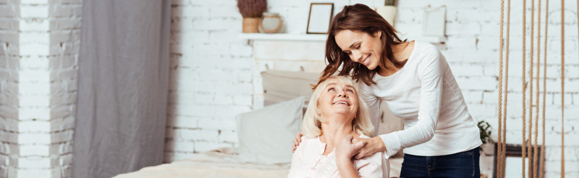 senior and a caregiver smiling each other