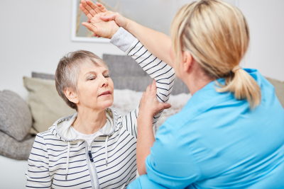 caregiver raising the shoulder of the senior