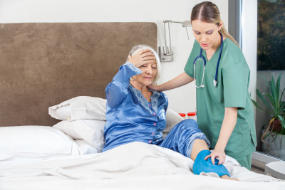 nurse giving care to a senior woman on bed