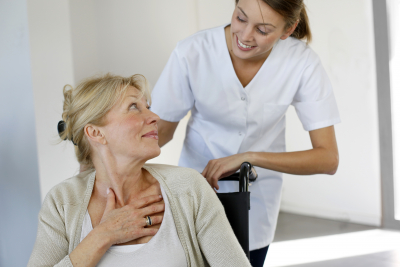 nurse and senior at wheelchair looking each other