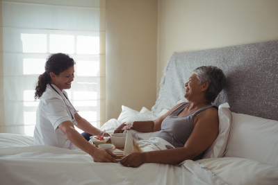 nurse serving food to a senior